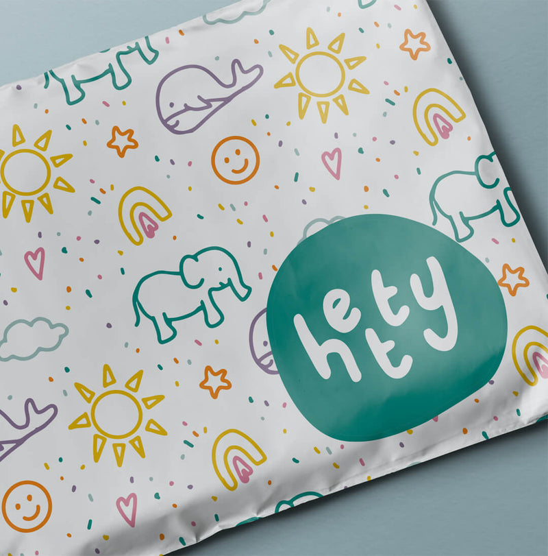 Children's blanket with colorful patterns and 'hey' logo on a light blue background